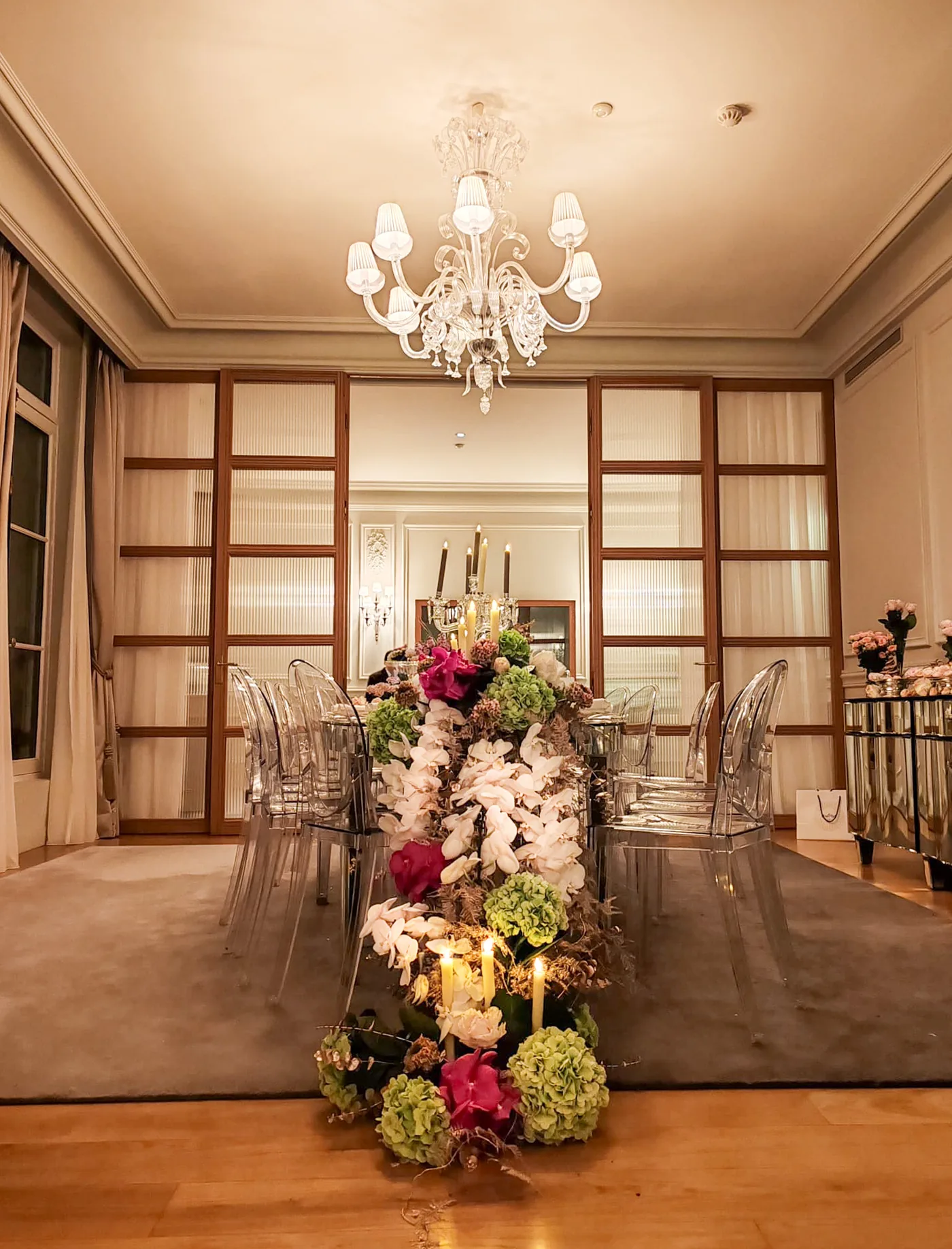 Grande composition florale verte, blanche et fuchsia traversant une table de réception aux chandelles — L’Atelier d’Olivier